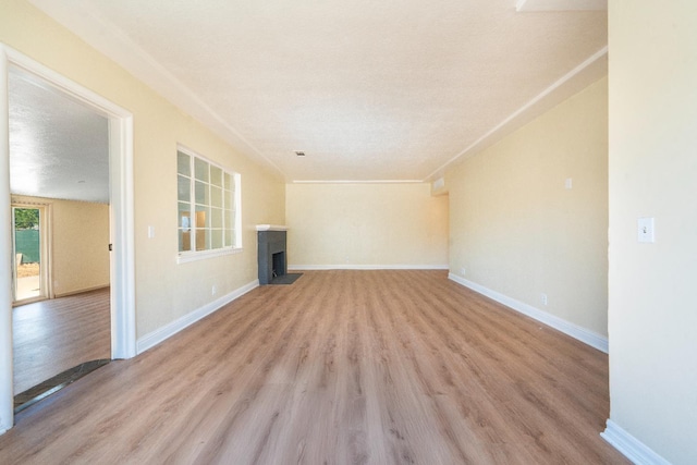 2744 E Michigan Ave, Fresno, CA 93703 - unfurnished living room featuring light wood finished floors, a fireplace with flush hearth, and baseboards