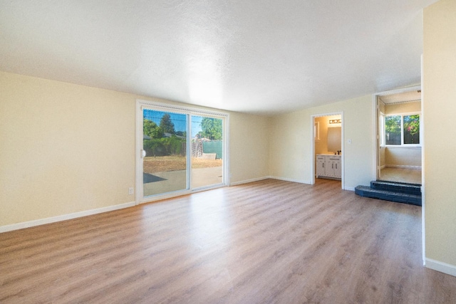 2744 E Michigan Ave, Fresno, CA 93703 - unfurnished living room featuring light wood-style floors and baseboards
