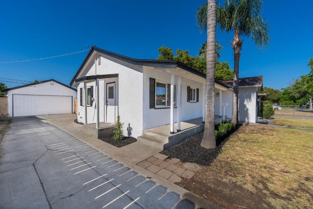 2744 E Michigan Ave, Fresno, CA 93703 - view of front facade with stucco siding, an outdoor structure, a detached garage, and a porch