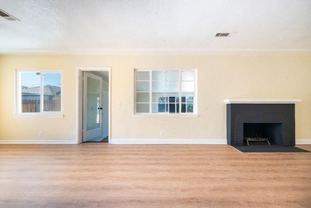 2744 E Michigan Ave, Fresno, CA 93703 - unfurnished living room featuring wood finished floors, baseboards, a textured ceiling, and a fireplace