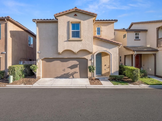 6053 E Brick Dr, Fresno, CA 93727 - view of front of house featuring stucco siding, a tile roof, a garage, and driveway
