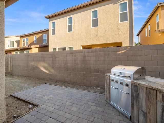 6053 E Brick Dr, Fresno, CA 93727 - fenced backyard featuring a patio area and an outdoor kitchen
