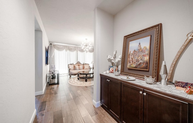 5615 N Lucy Ruiz Ave, Fresno, CA 93723 - corridor featuring a chandelier, light wood-type flooring, and baseboards