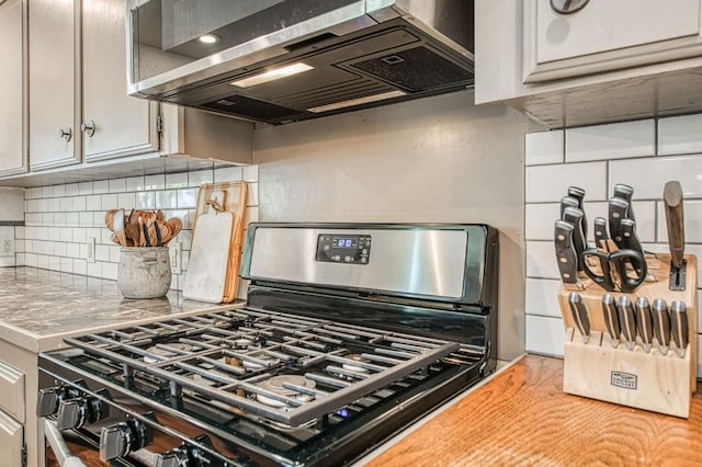 4461 N Winery Ave, Fresno, CA 93726 - kitchen with stainless steel range with gas stovetop, extractor fan, tasteful backsplash, and light countertops