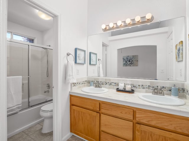 6185 N Milburn Ave, Fresno, CA 93722 - bathroom featuring double vanity, toilet, enclosed tub / shower combo, and tile patterned floors