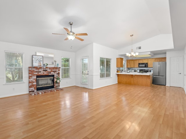 6185 N Milburn Ave, Fresno, CA 93722 - unfurnished living room with lofted ceiling, a chandelier, ceiling fan, a fireplace, and light wood-style floors