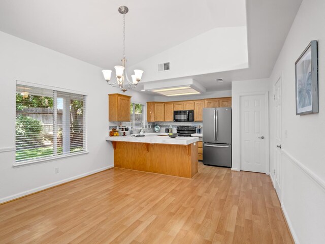6185 N Milburn Ave, Fresno, CA 93722 - kitchen with freestanding refrigerator, black microwave, range, a chandelier, and a peninsula