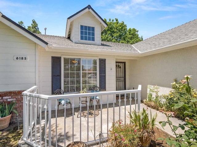 6185 N Milburn Ave, Fresno, CA 93722 - entrance to property featuring a shingled roof and brick siding