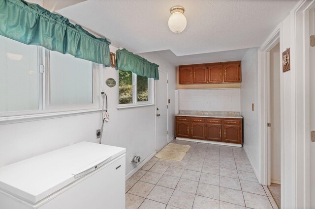37731 Shoreline Dr, Bass Lake, CA 93604 - washroom with light tile patterned floors, cabinet space, and baseboards