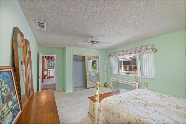 37731 Shoreline Dr, Bass Lake, CA 93604 - carpeted bedroom with a closet, multiple windows, a textured ceiling, a ceiling fan, and baseboards
