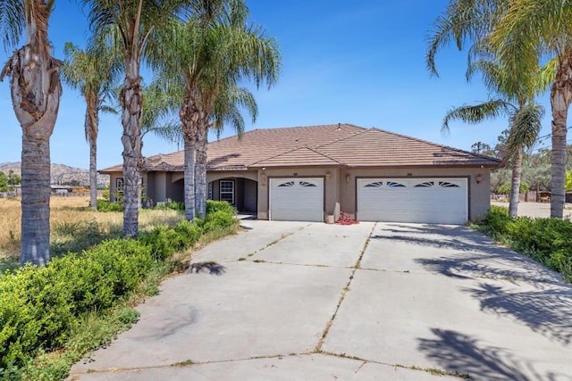 42462 Rd 140, Orosi, CA 93647 - ranch-style house with driveway, stucco siding, a garage, and a tiled roof