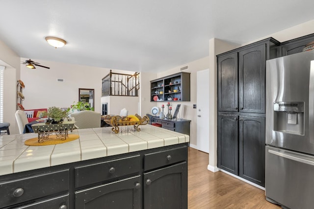 1775 E Cole Ave, Fresno, CA 93720 - kitchen featuring stainless steel fridge, tile counters, wood finished floors, and ceiling fan