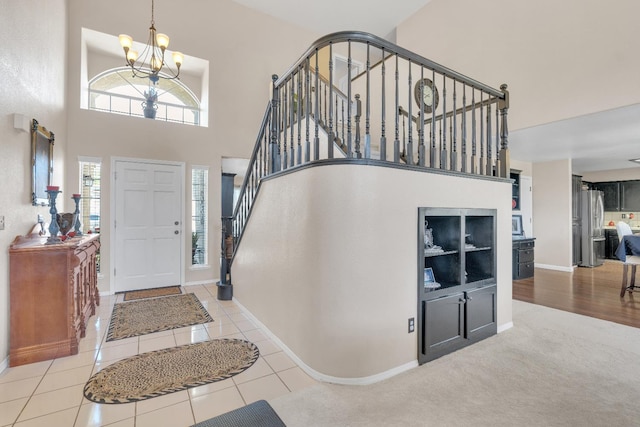 1775 E Cole Ave, Fresno, CA 93720 - entryway featuring a chandelier, a towering ceiling, stairway, baseboards, and tile patterned flooring