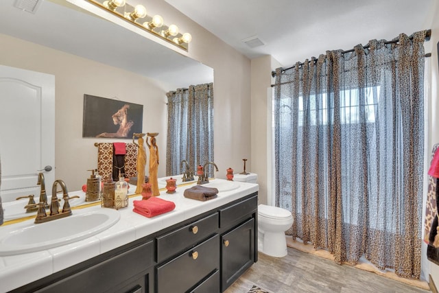 1775 E Cole Ave, Fresno, CA 93720 - bathroom featuring double vanity, toilet, and wood finished floors