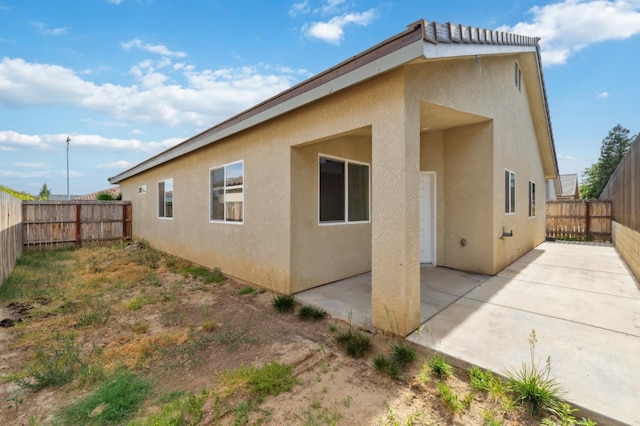 1061 Adell St, Madera, CA 93638 - rear view of house featuring stucco siding, a patio, and a fenced backyard