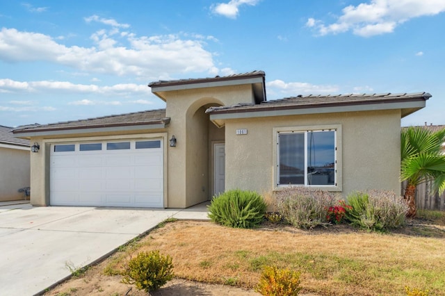 1061 Adell St, Madera, CA 93638 - view of front facade with a garage, stucco siding, driveway, and a front lawn