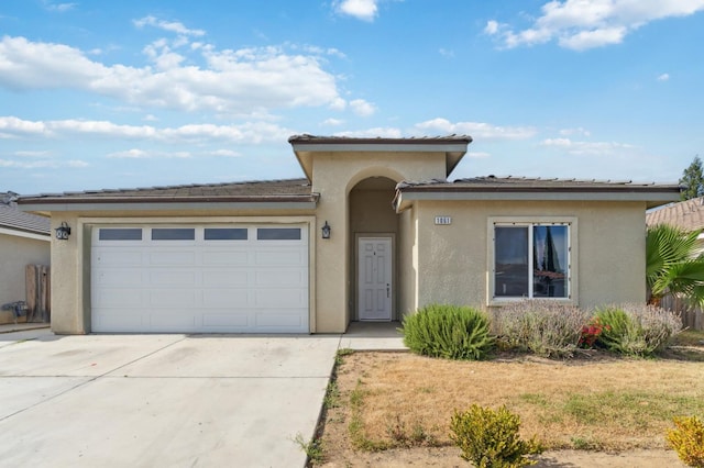 1061 Adell St, Madera, CA 93638 - view of front facade with concrete driveway, stucco siding, a garage, and a tile roof