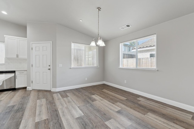 1061 Adell St, Madera, CA 93638 - unfurnished dining area with a chandelier, wood finished floors, lofted ceiling, baseboards, and recessed lighting