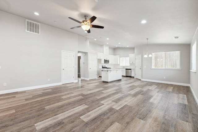 1061 Adell St, Madera, CA 93638 - unfurnished living room featuring a ceiling fan, recessed lighting, baseboards, light wood-type flooring, and high vaulted ceiling