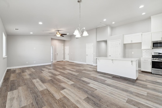 1061 Adell St, Madera, CA 93638 - kitchen featuring stainless steel appliances, white cabinetry, light countertops, open floor plan, and recessed lighting