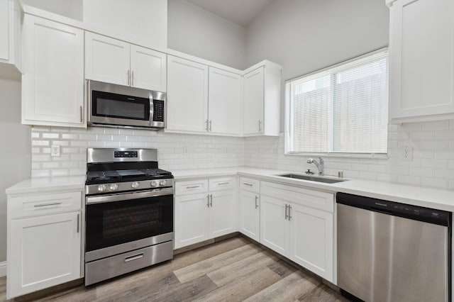 1061 Adell St, Madera, CA 93638 - kitchen with stainless steel appliances, a sink, light countertops, and white cabinets