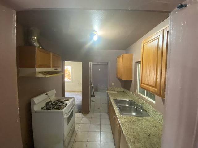 1325 S 4th St, Fresno, CA 93702 - kitchen with white range with gas cooktop, a sink, light countertops, under cabinet range hood, and light tile patterned flooring