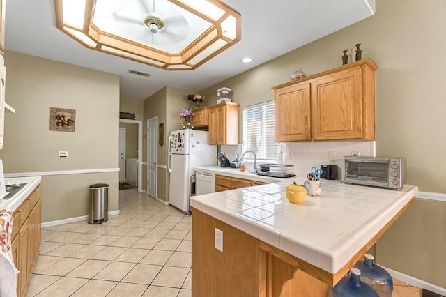 10033 N Baird Ave, Fresno, CA 93730 - kitchen featuring tile counters, white appliances, light tile patterned floors, a peninsula, and recessed lighting