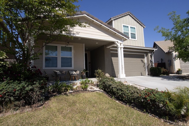 116 Meridian Ave, Madera, CA 93636 - view of front of property with board and batten siding, covered porch, driveway, a front yard, and a garage