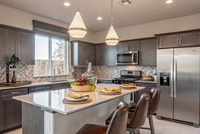 1157 Maclure Ave W, Madera, CA 93636 - kitchen with appliances with stainless steel finishes, a sink, dark brown cabinets, a kitchen island, and backsplash
