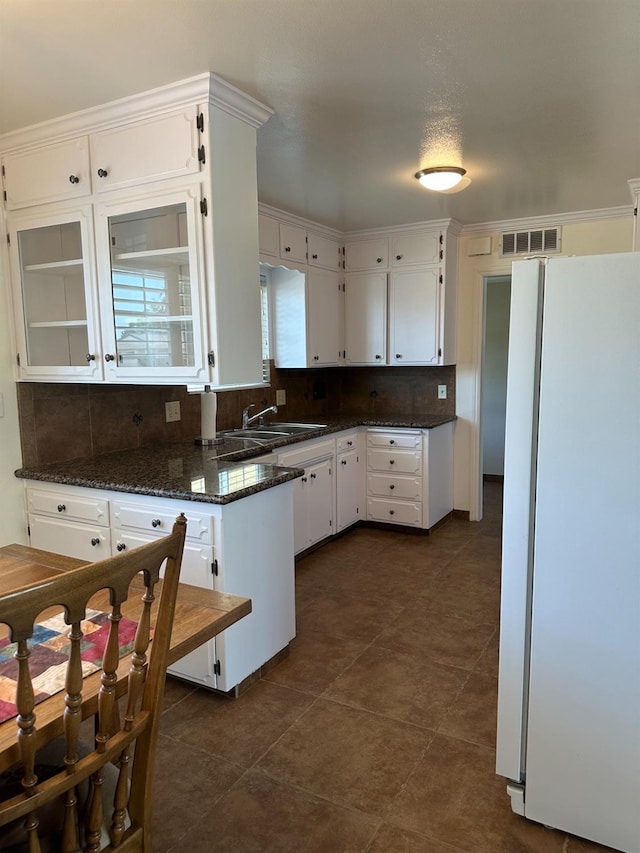 6538 N 4th St, Fresno, CA 93710 - kitchen featuring freestanding refrigerator, white cabinetry, decorative backsplash, dark stone counters, and dark tile patterned floors