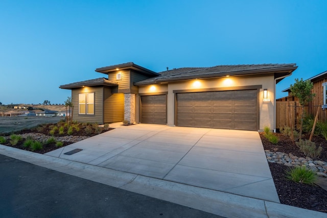 8152 Creek Vw, Friant, CA 93626 - prairie-style home featuring a garage, concrete driveway, a tile roof, and stucco siding
