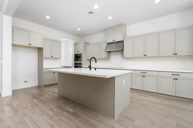 8152 Creek Vw, Friant, CA 93626 - kitchen featuring under cabinet range hood, stainless steel appliances, light wood-type flooring, recessed lighting, and light countertops