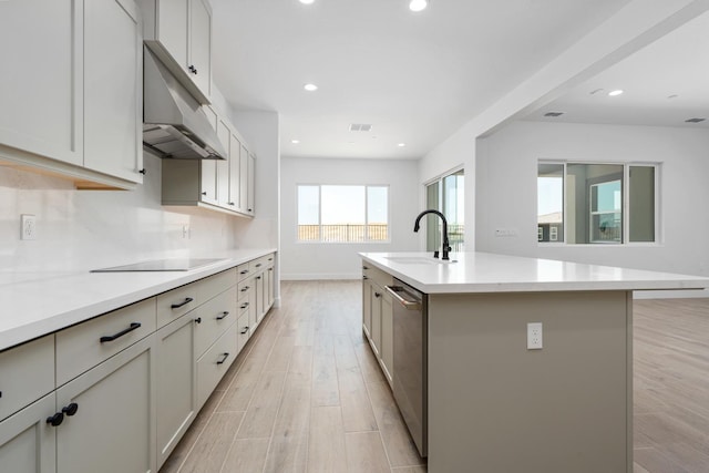 8152 Creek Vw, Friant, CA 93626 - kitchen featuring black electric cooktop, stainless steel dishwasher, light wood-type flooring, light countertops, and a center island with sink
