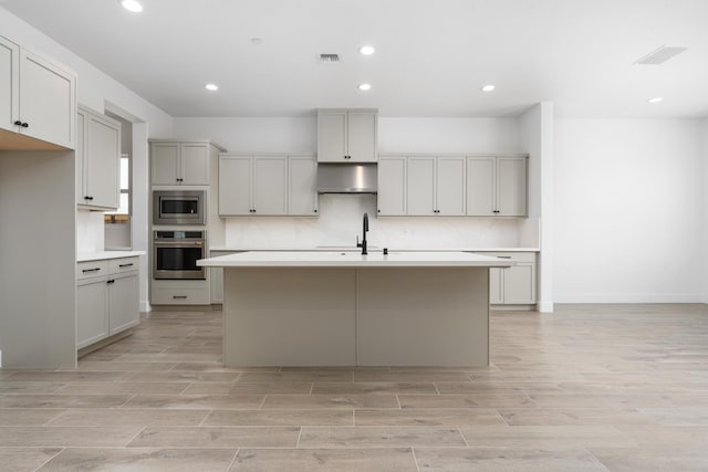 8152 Creek Vw, Friant, CA 93626 - kitchen with stainless steel appliances, under cabinet range hood, light wood-style floors, recessed lighting, and light countertops