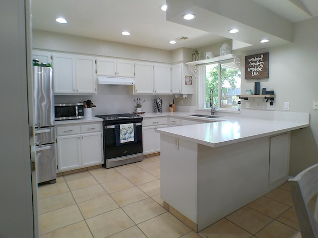 1561 Josephine Ct, Madera, CA 93638 - kitchen featuring appliances with stainless steel finishes, a sink, under cabinet range hood, a peninsula, and white cabinetry