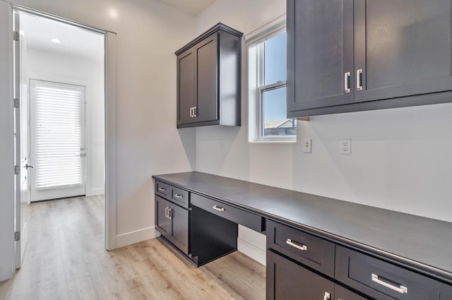 1734 Lester Ave, Clovis, CA 93619 - kitchen featuring light wood-style flooring, baseboards, dark countertops, and a desk