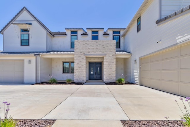 1734 Lester Ave, Clovis, CA 93619 - view of front of home with a standing seam roof, a garage, concrete driveway, and french doors