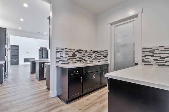 1734 Lester Ave, Clovis, CA 93619 - kitchen featuring a sink, light wood-type flooring, recessed lighting, tasteful backsplash, and light countertops