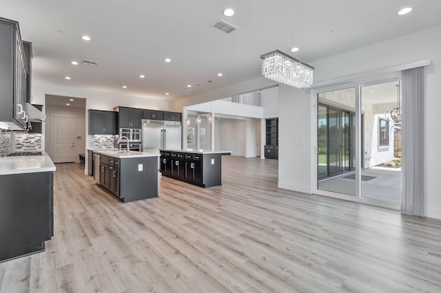 1734 Lester Ave, Clovis, CA 93619 - kitchen with a chandelier, a kitchen island with sink, stainless steel built in refrigerator, a sink, and recessed lighting