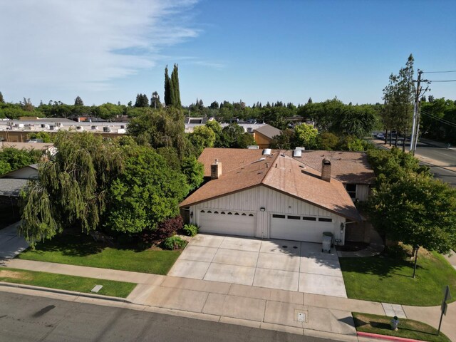 1785 W Calimyrna Ave Unit A, Fresno, CA 93711 - view of front of home with driveway, an attached garage, a front lawn, board and batten siding, and a shingled roof
