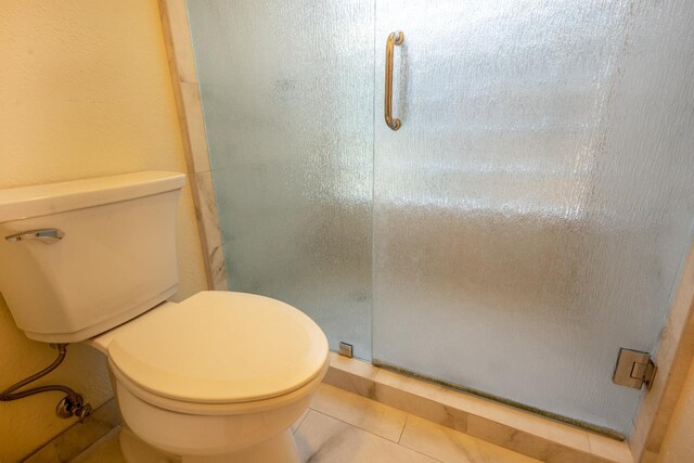 1785 W Calimyrna Ave Unit A, Fresno, CA 93711 - bathroom featuring a stall shower, toilet, and tile patterned flooring