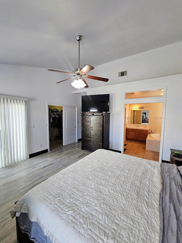 5453 N San Clemente Ave, Fresno, CA 93723 - bedroom with ensuite bath, a walk in closet, a ceiling fan, baseboards, and a barn door