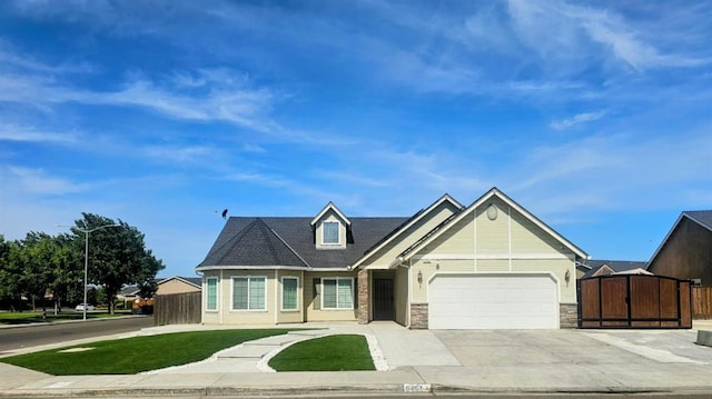 5453 N San Clemente Ave, Fresno, CA 93723 - view of front of house with concrete driveway, an attached garage, and stone siding