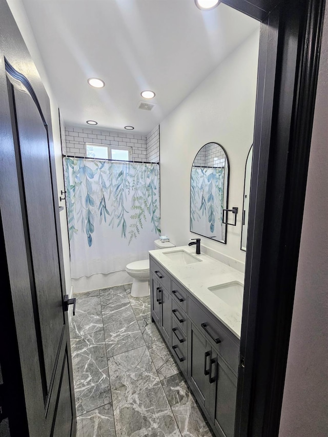 5453 N San Clemente Ave, Fresno, CA 93723 - bathroom with toilet, double vanity, marble look tile flooring, recessed lighting, and shower / tub combo with curtain