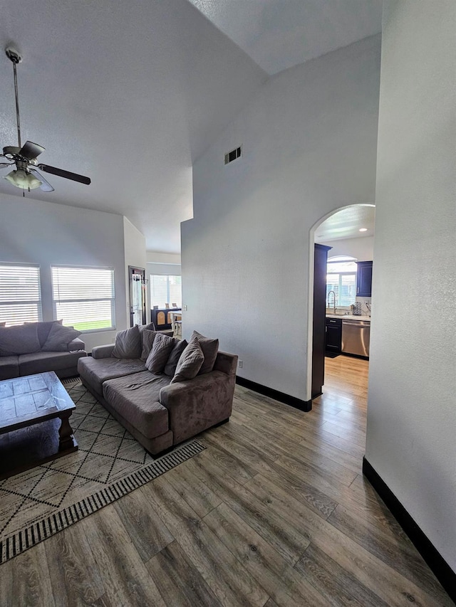 5453 N San Clemente Ave, Fresno, CA 93723 - living room with ceiling fan, arched walkways, high vaulted ceiling, wood finished floors, and baseboards