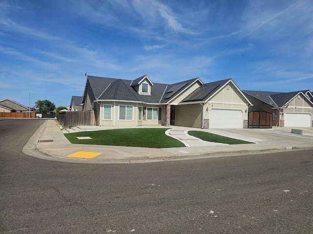 5453 N San Clemente Ave, Fresno, CA 93723 - view of front of house with an attached garage, concrete driveway, stone siding, and solar panels