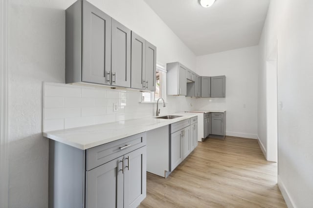 630 N Roosevelt Ave, Fresno, CA 93728 - kitchen with gray cabinets, a sink, decorative backsplash, and baseboards