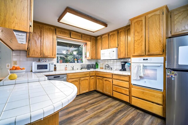 200 Autumn Rd, Madera, CA 93637 - kitchen featuring appliances with stainless steel finishes, tile countertops, decorative backsplash, and dark wood-style flooring