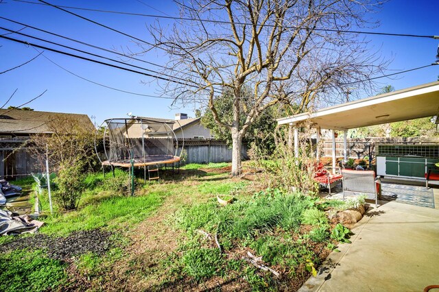 200 Autumn Rd, Madera, CA 93637 - fenced backyard with a trampoline and a patio