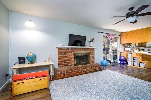 200 Autumn Rd, Madera, CA 93637 - living room featuring dark wood-style floors, ceiling fan, a brick fireplace, and baseboards